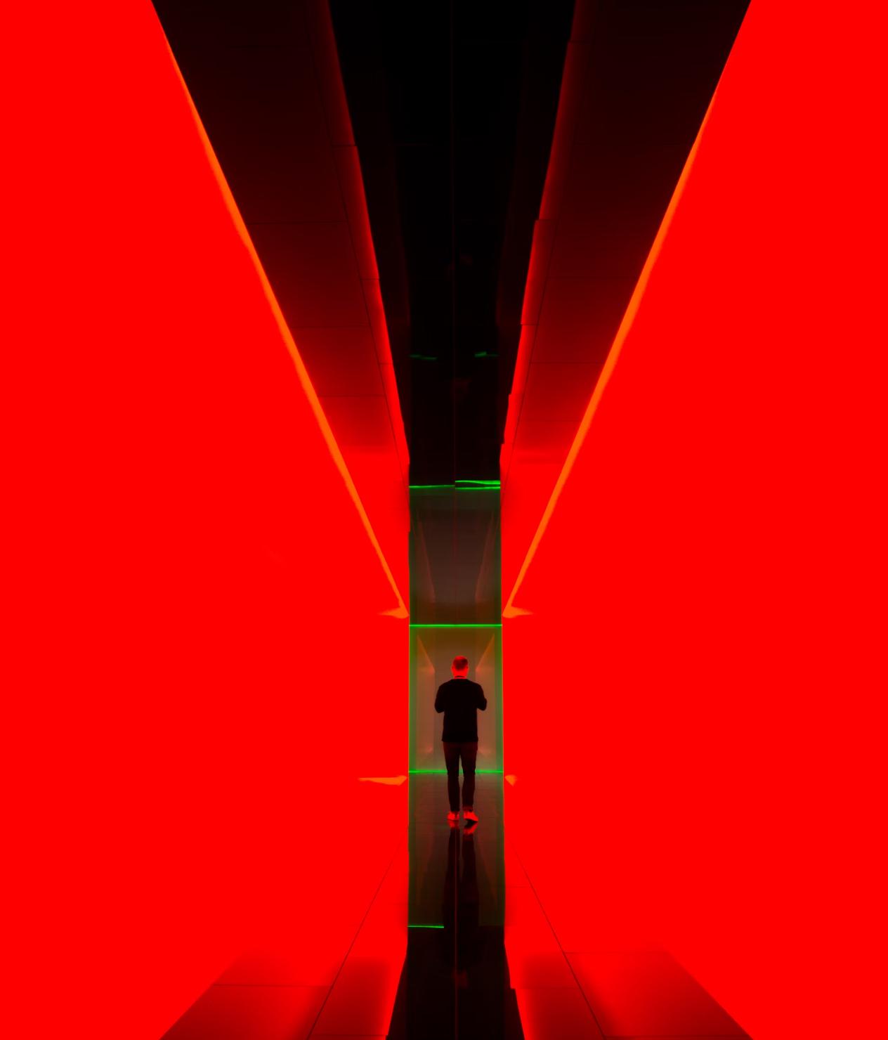 Image d'une personne au fond d'un couloir rouge